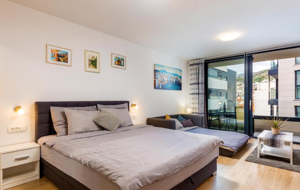 een slaapkamer met een groot bed en een groot raam bij Nomad Dubrovnik + free parking in Dubrovnik