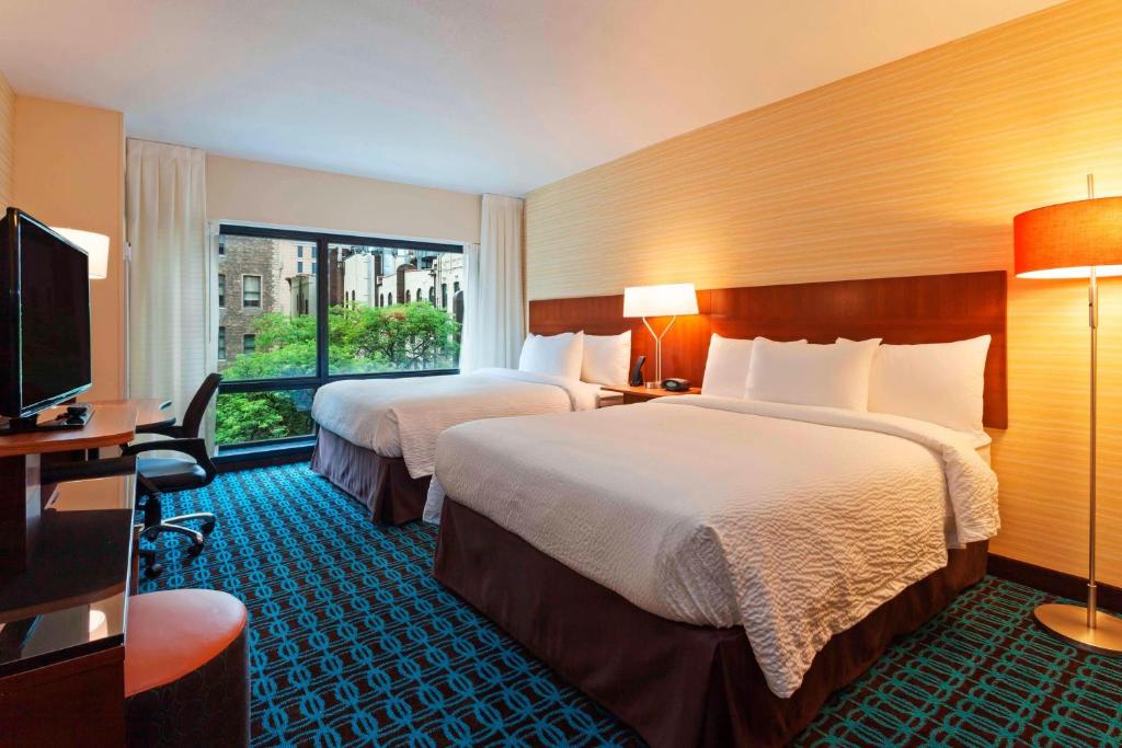 a hotel room with two beds and a flat screen tv at Fairfield Inn and Suites Chicago Downtown-River North in Chicago