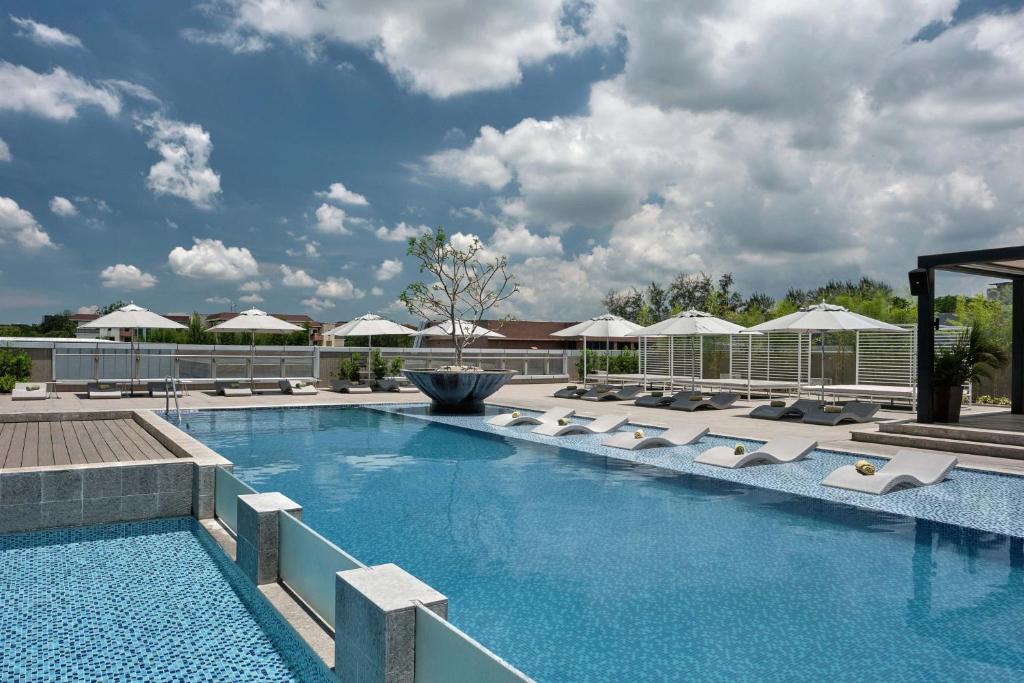 a large swimming pool with lounge chairs and umbrellas at Clark Marriott Hotel in Clark