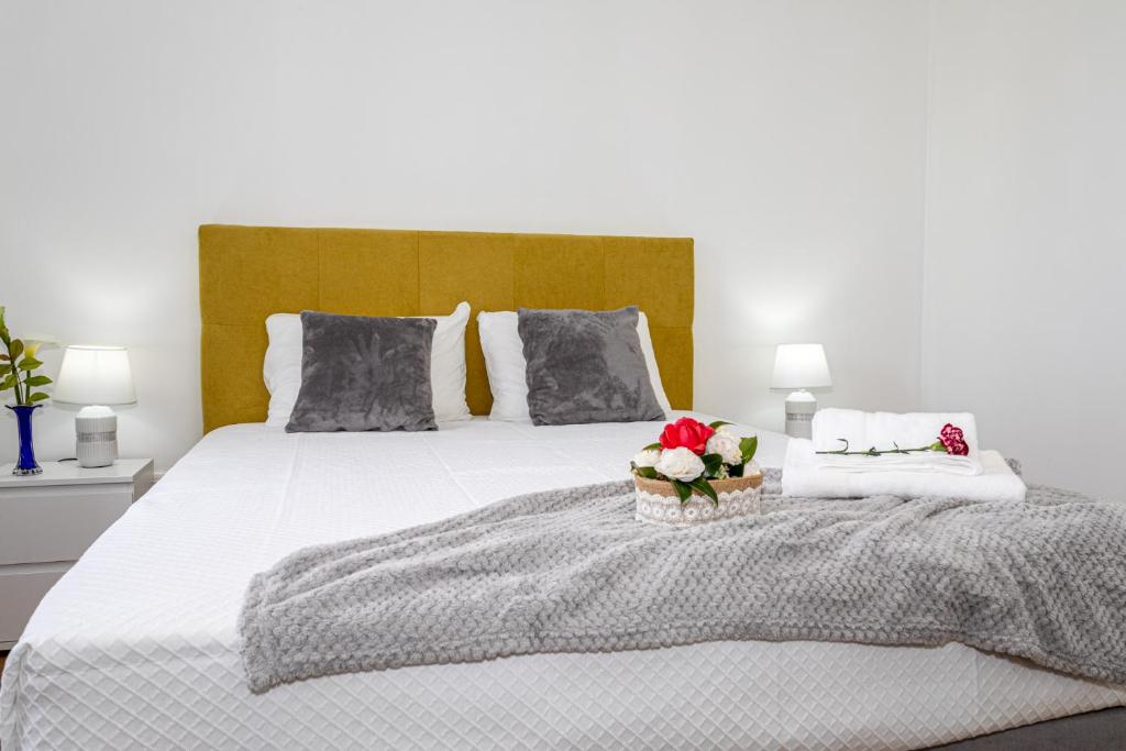 een slaapkamer met een wit bed met bloemen erop bij Oásis Fonte Grande in Santo António