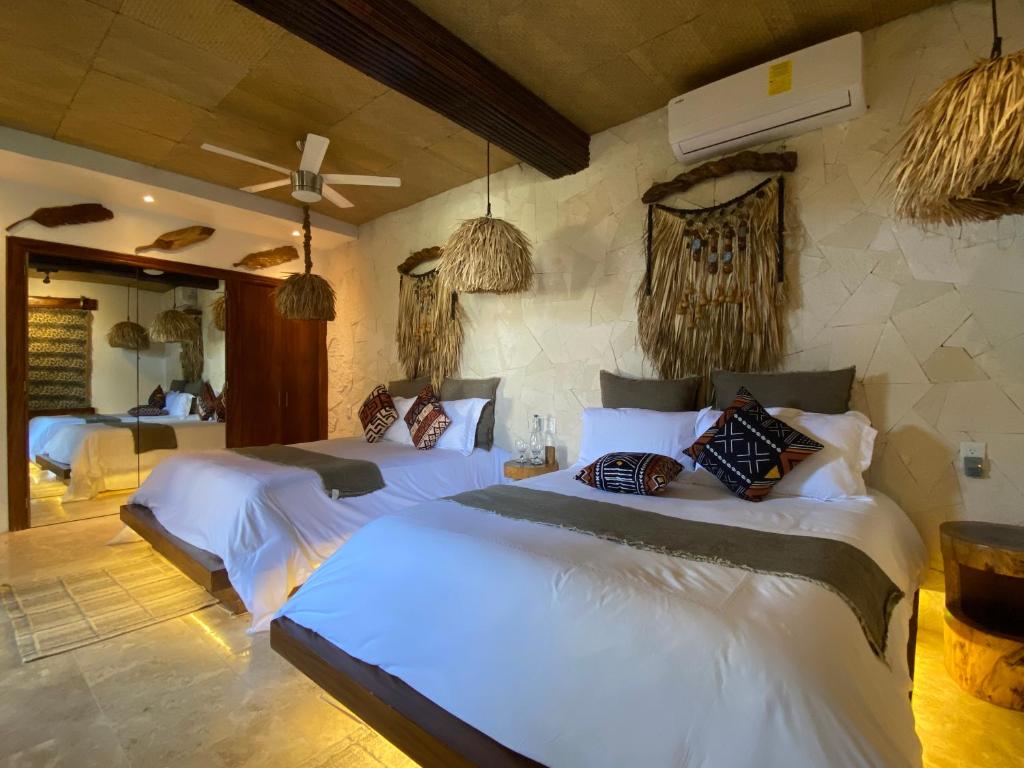 een slaapkamer met 2 bedden in een kamer bij Muúnek Hotel Boutique Art & Spa in Barra Vieja