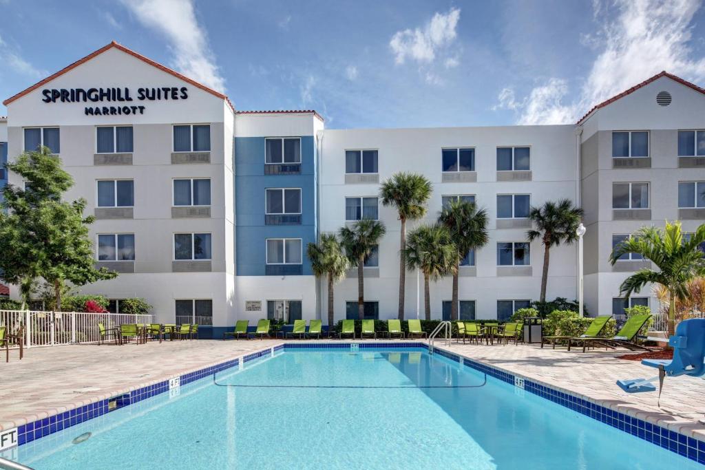 a hotel with a swimming pool in front of a building at SpringHill Suites Port Saint Lucie in Port Saint Lucie