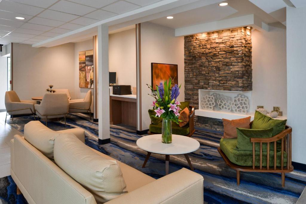 a waiting room with a couch and chairs and a fireplace at Fairfield Inn Arlington Near Six Flags in Arlington