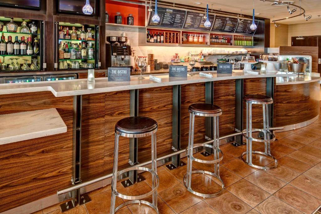 a bar in a restaurant with stools at Courtyard by Marriott Midland in Midland