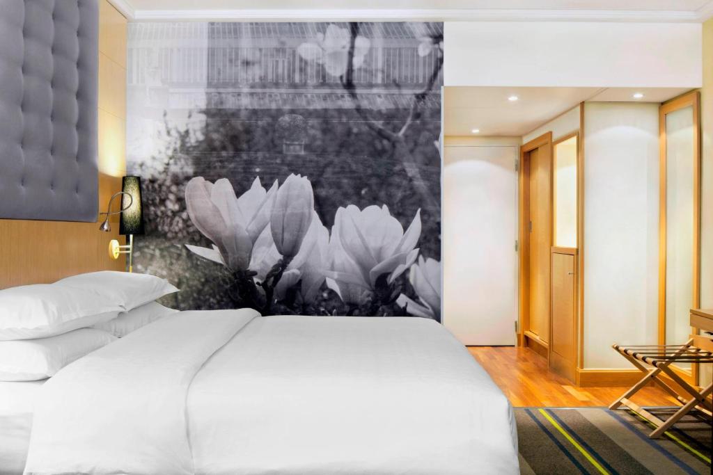 a bedroom with a white bed and a black and white painting at Sheraton Brussels Airport Hotel in Zaventem