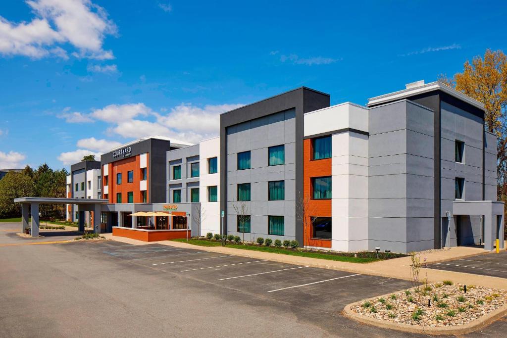 een weergave van een gebouw op een parkeerplaats bij Courtyard by Marriott Albany Thruway in Albany