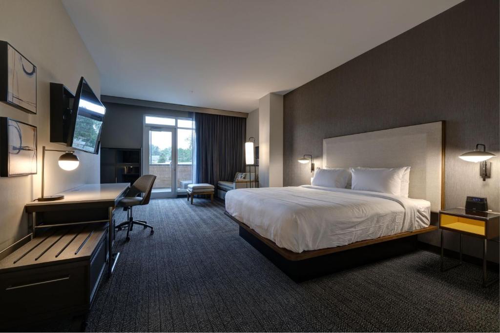 a hotel room with a bed and a desk at Courtyard by Marriott Iowa City University Heights in Iowa City