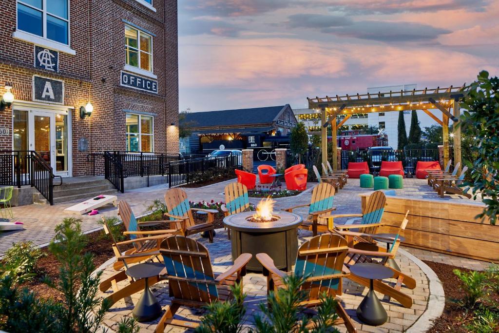 a patio with chairs and a fire pit in front of a building at Aloft Wilmington at Coastline Center in Wilmington