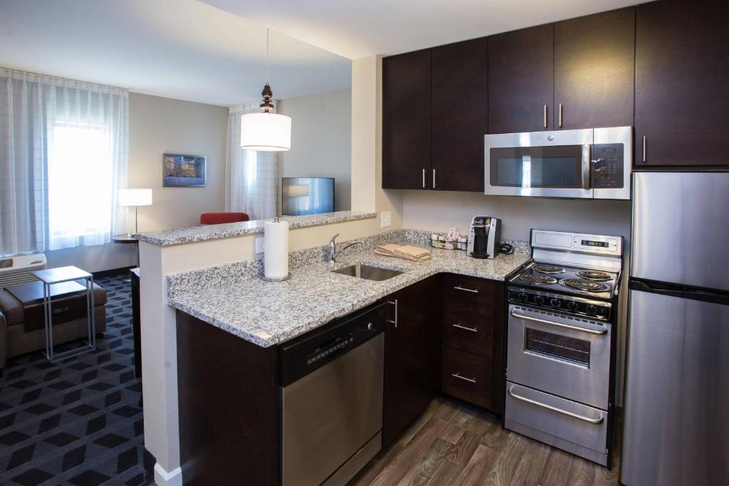 a kitchen with stainless steel appliances in a hotel room at TownePlace Suites by Marriott Southern Pines Aberdeen in Aberdeen
