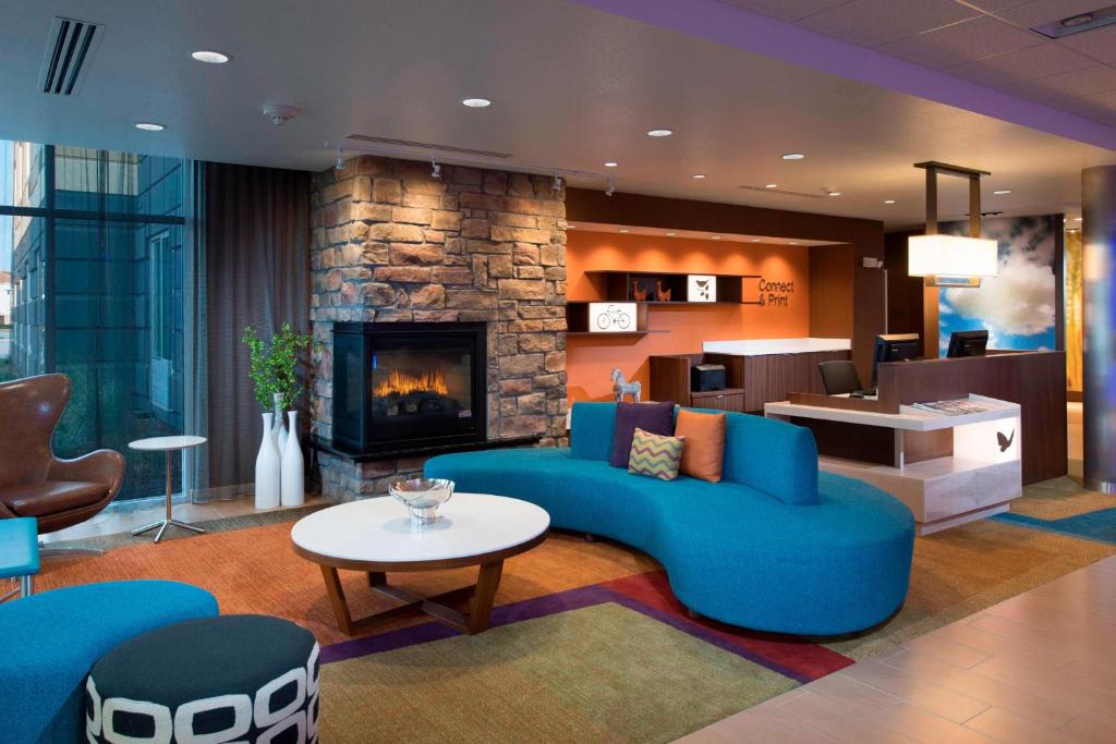 a living room with a blue couch and a fireplace at Fairfield Inn & Suites by Marriott Scottsbluff in Scottsbluff