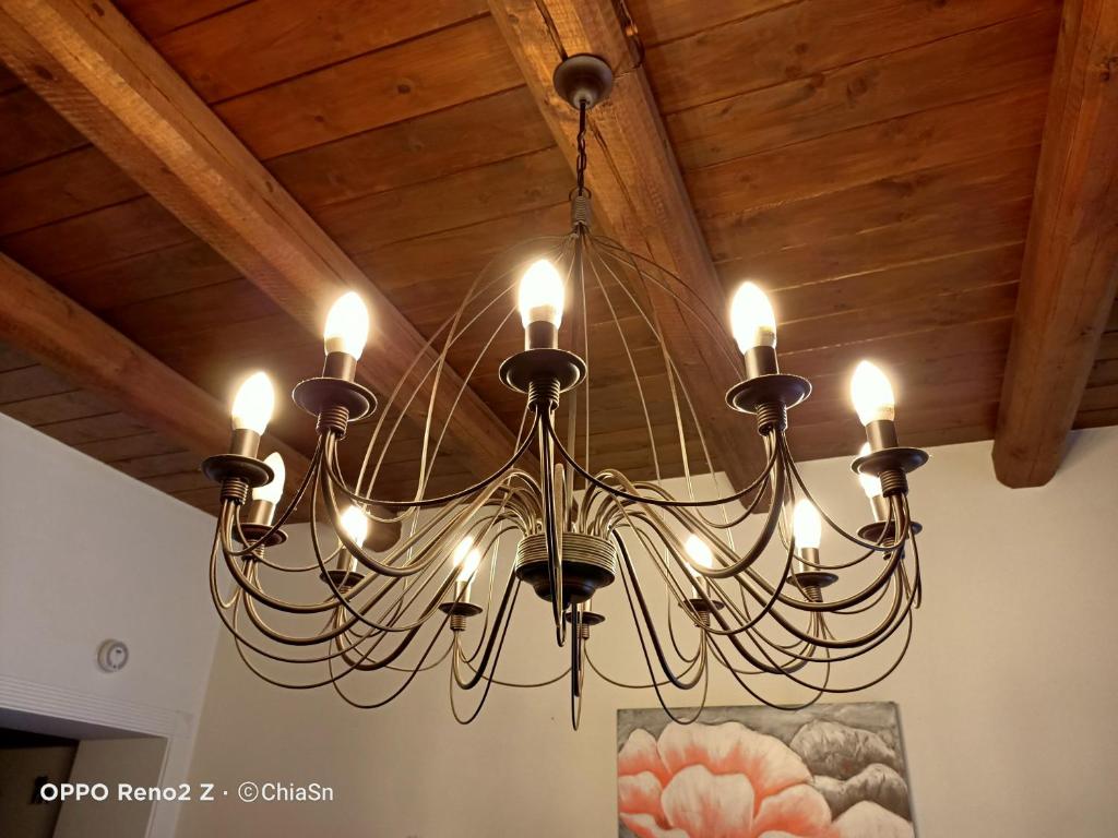 una lámpara de araña colgada de un techo de madera en A Casa di Marti, en Loreto