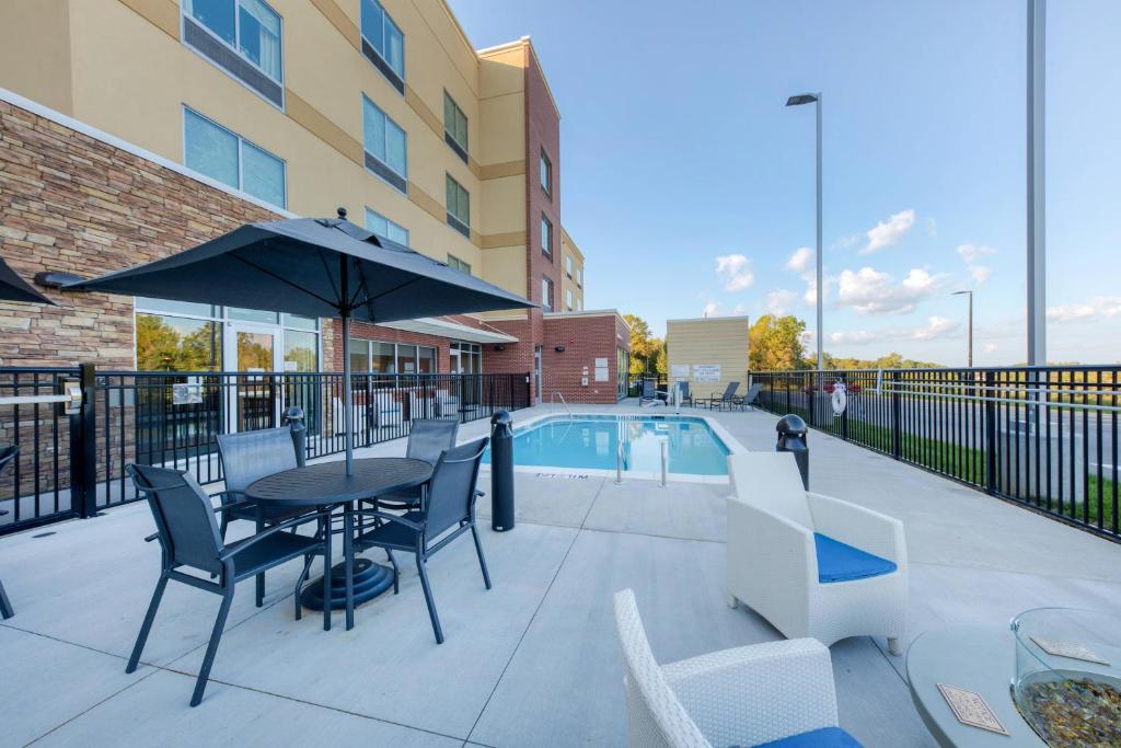 a patio with a table and chairs and a pool at Fairfield Inn & Suites by Marriott Charlotte Belmont in Belmont