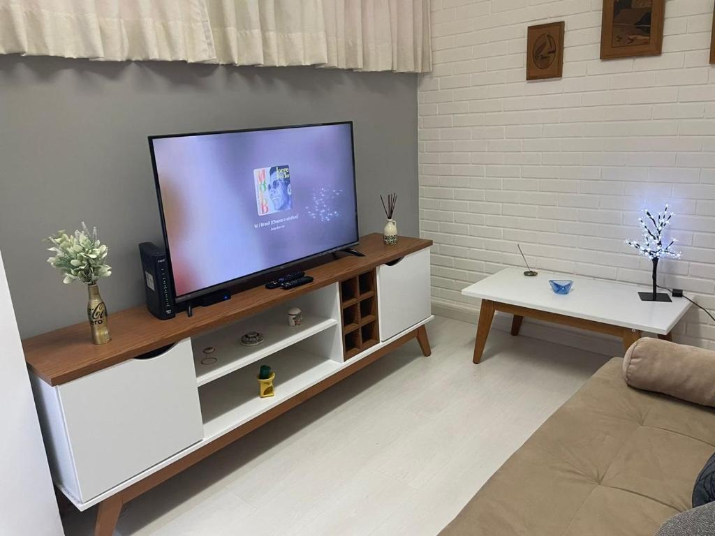 a living room with a flat screen tv on a white cabinet at Apto com Wi-Fi a 200m da Praia de Copacabana/RJ - Cp3 in Rio de Janeiro