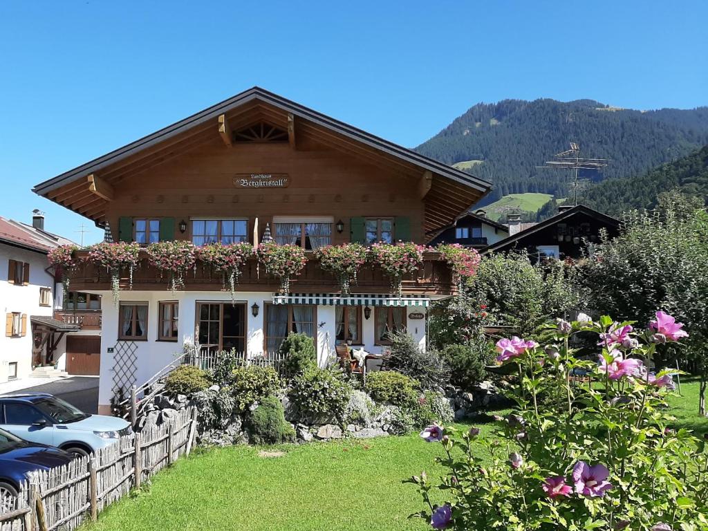 a house with a balcony with flowers on it at Landhaus Bergkristall - Sommer Bergbahnen inklusive in Oberstdorf