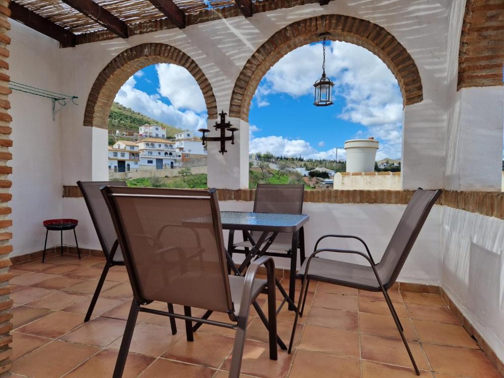 Casa El Banco في Iznate: غرفة طعام مع طاولة وكراسي على شرفة