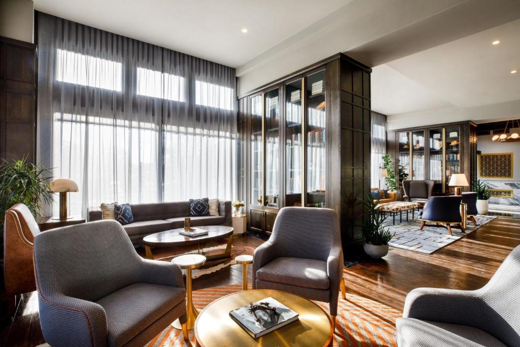 a lobby with chairs and tables and windows at The Barfield, Autograph Collection in Amarillo