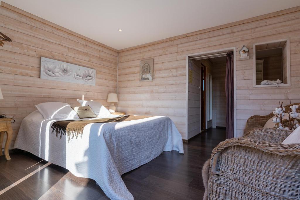 ein Schlafzimmer mit einem Bett in einem Zimmer mit Holzwänden in der Unterkunft Chambres Du Marais in Tilques