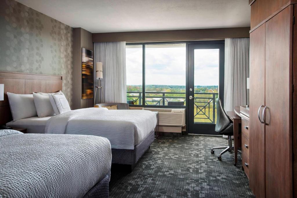 a hotel room with two beds and a balcony at Courtyard by Marriott Philadelphia Lansdale in Lansdale