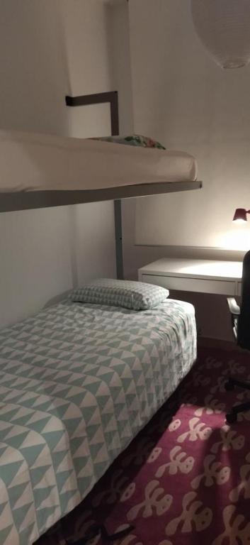 niewielka sypialnia z łóżkiem piętrowym i dywanem w obiekcie LA CASITA DE LA PUERTA DE CARMONA w Sewilli