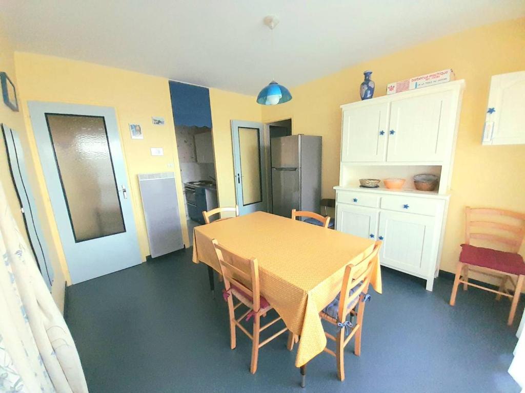 uma cozinha com uma mesa e cadeiras e um frigorífico em Appartement Saint-Hilaire-de-Riez, 2 pièces, 5 personnes - FR-1-324A-2 em Saint-Hilaire-de-Riez