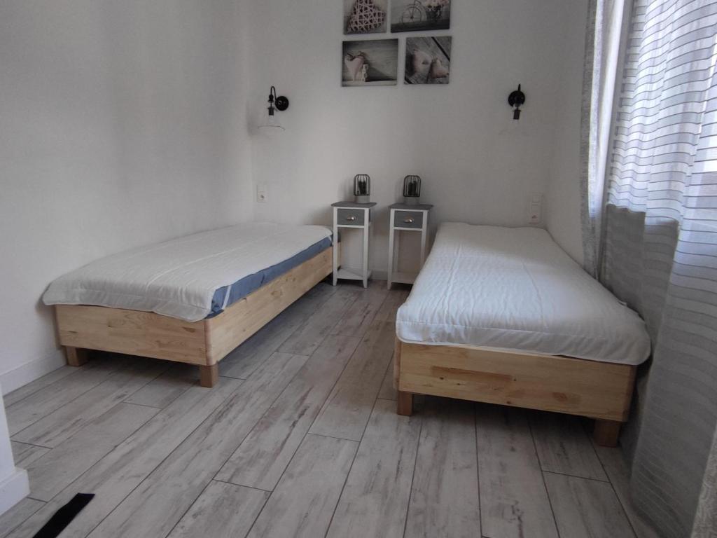 2 camas en una habitación con suelo de madera en Apartament Homole E2 Szczawnica en Szczawnica