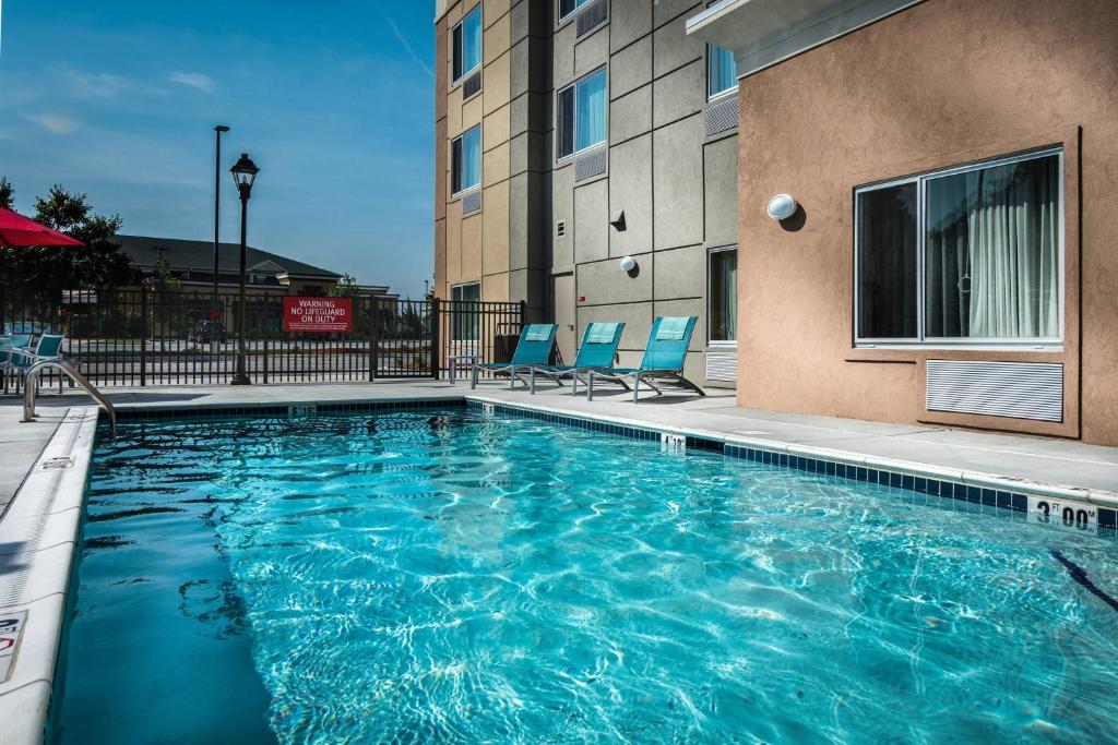 una piscina con sedie blu e un edificio di TownePlace Suites by Marriott Goldsboro a Goldsboro