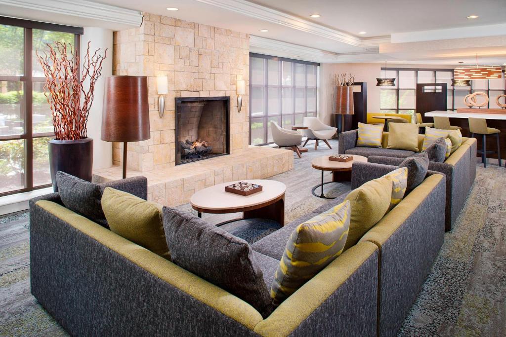 una gran sala de estar con sofás y chimenea. en Courtyard by Marriott Ann Arbor, en Ann Arbor