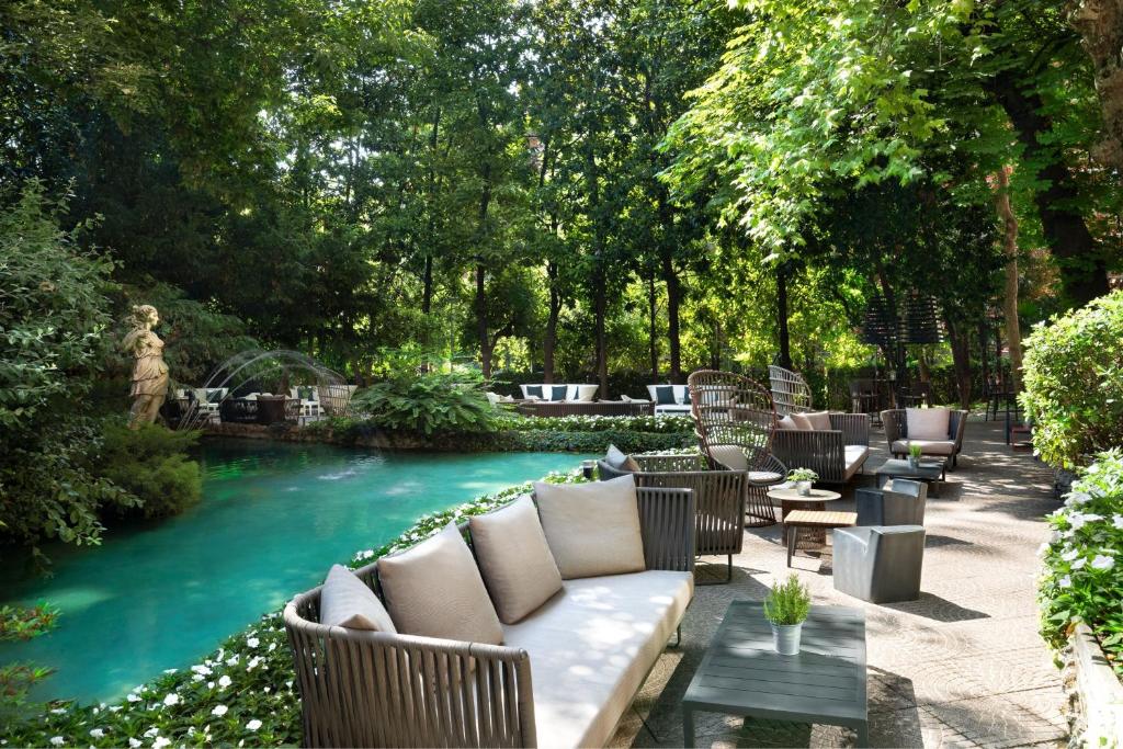 a pool with a couch and chairs in a yard at Sheraton Diana Majestic in Milan