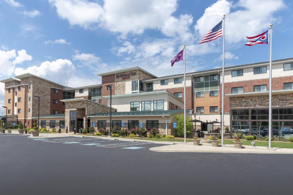 Un edificio con due bandiere americane davanti. di Residence Inn by Marriott Akron South/Green ad Akron