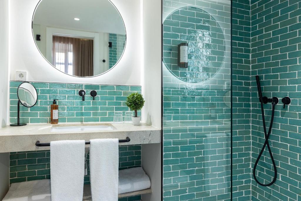 a blue tiled bathroom with a sink and a mirror at Samaritana Suites in Palma de Mallorca