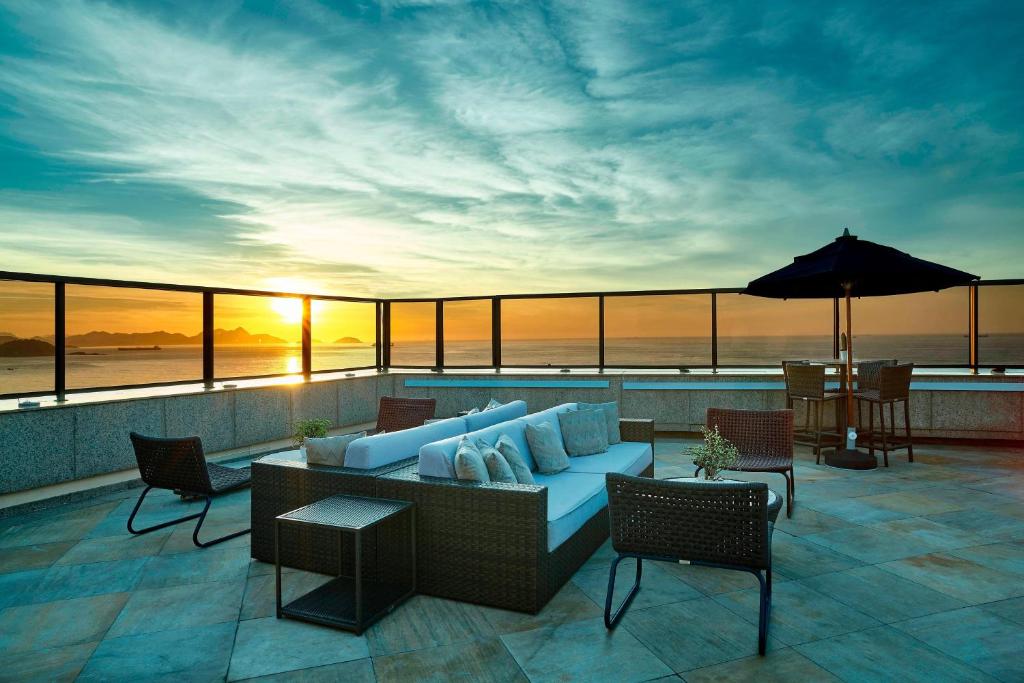 a patio with a couch and chairs and an umbrella at JW Marriott Rio de Janeiro in Rio de Janeiro