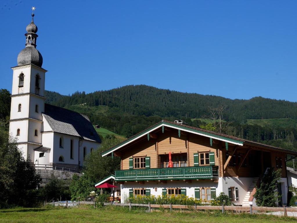 a building with a clock tower next to a church at Berg-Loft Ramsau in Ramsau