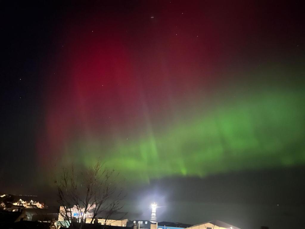an aurora in the sky over a city at night at Kintrae B&B in Buckie