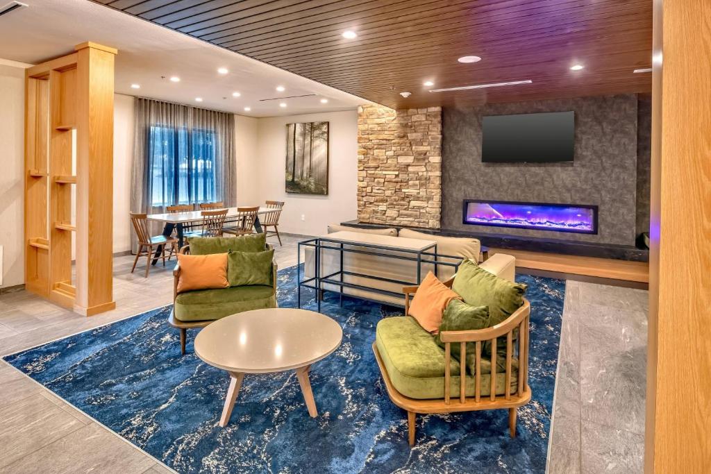 vestíbulo con sillas, TV y mesa en Fairfield Inn & Suites Fort Worth Northeast, en Hurst
