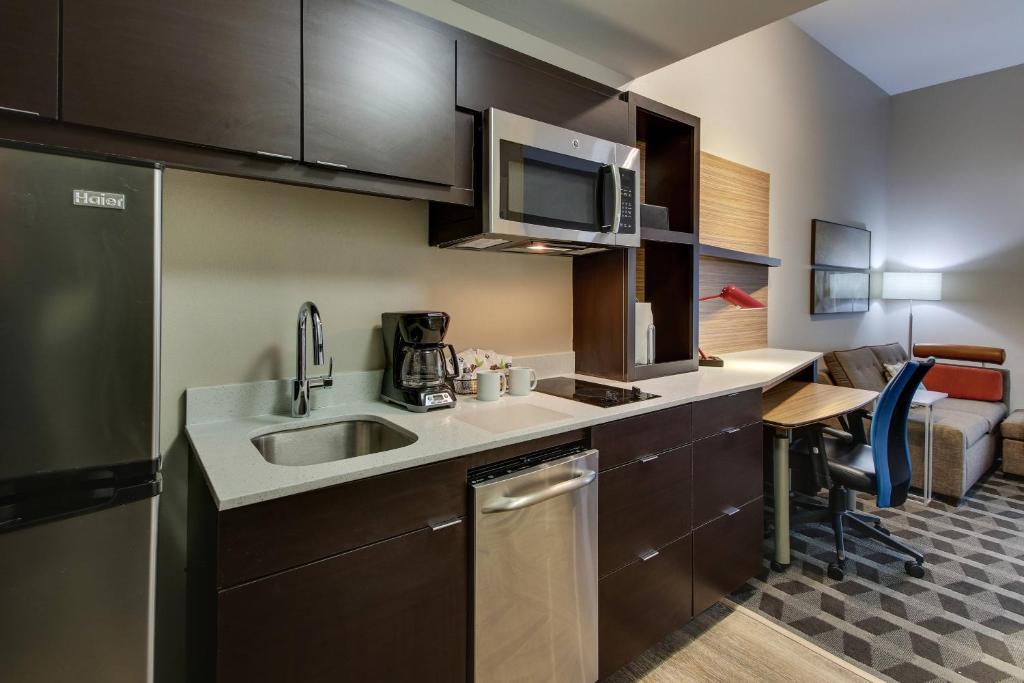 a small kitchen with a sink and a microwave at TownePlace Suites by Marriott Mobile Saraland in Saraland