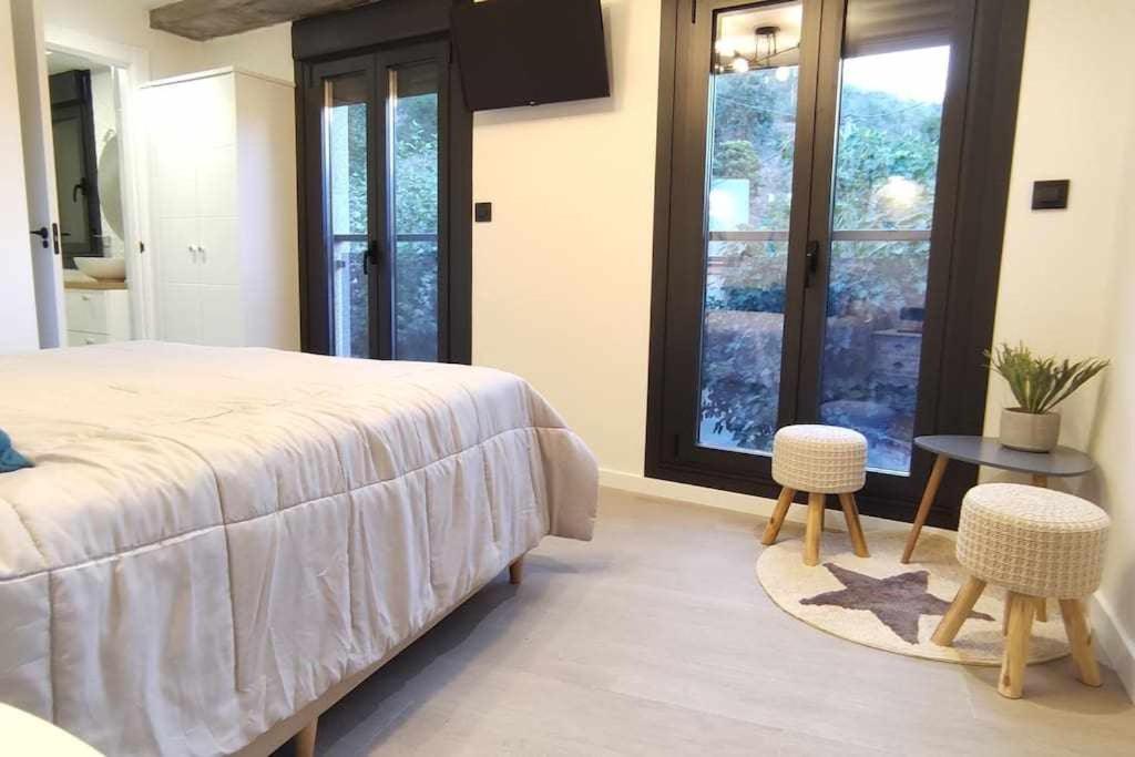 a bedroom with a bed and two chairs and a table at Precioso Apartamento de 1 Habitación in O Barco de Valdeorras