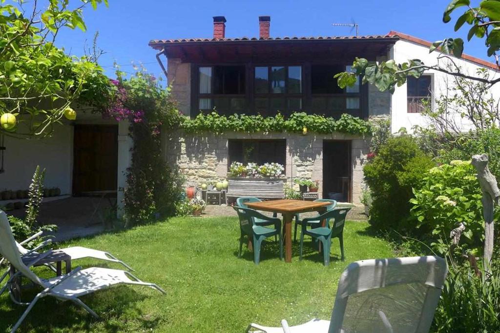 einen Garten mit einem Tisch und Stühlen vor einem Haus in der Unterkunft Casa Rural Nel NRGA002R in Bojes