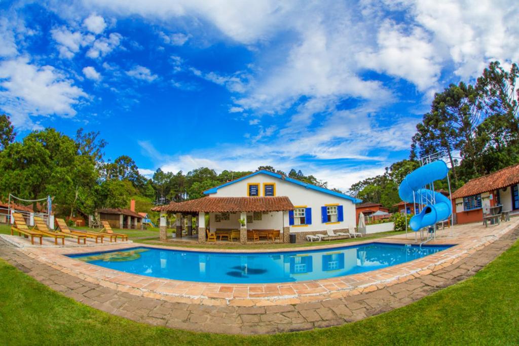une grande piscine en face d'une maison dans l'établissement Pousada Águas do Vale, à Atibaia