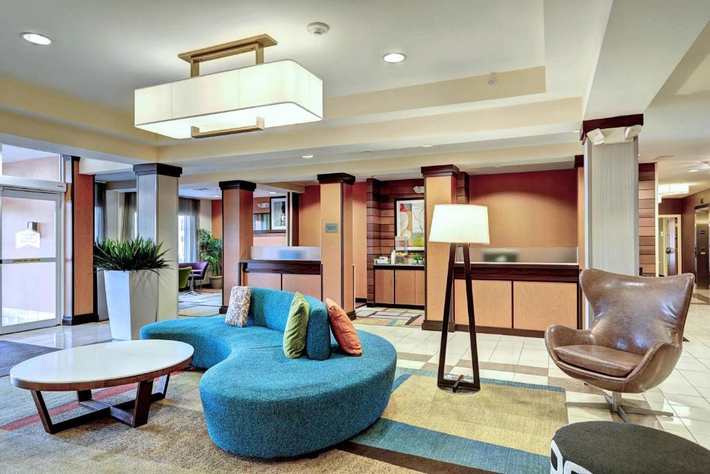 uma sala de estar com um sofá azul e uma cadeira em Fairfield Inn & Suites by Marriott Edison - South Plainfield em Edison