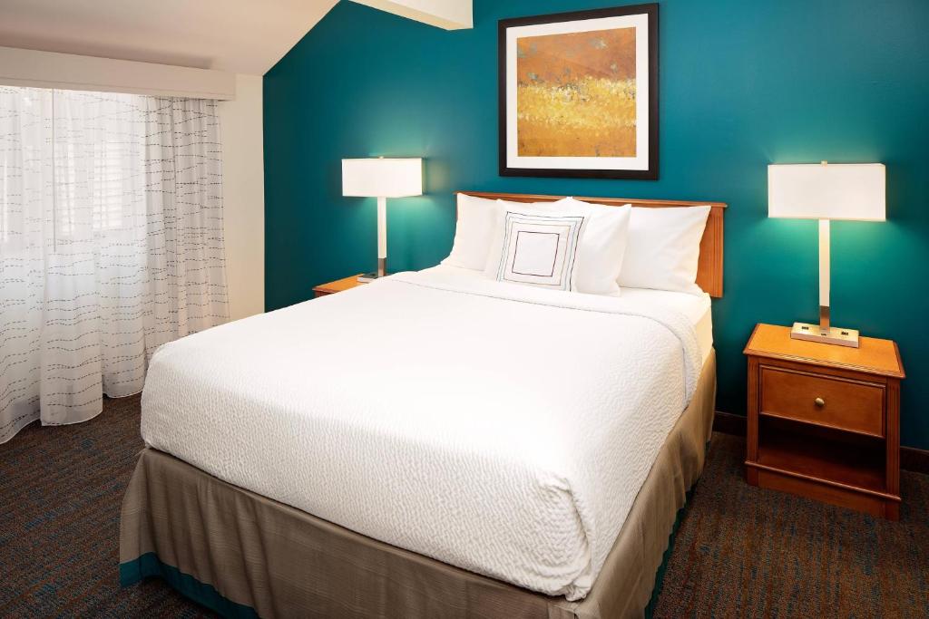 a bedroom with a large white bed and a blue wall at Residence Inn Harrisburg Hershey in Harrisburg