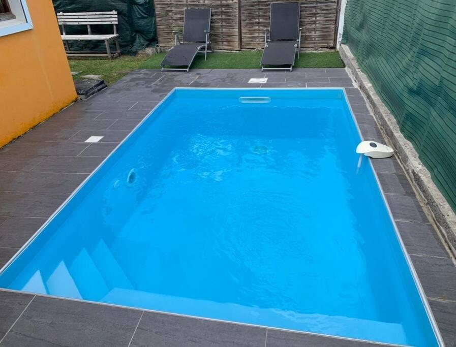 a large blue swimming pool on a patio at Charmante Villa avec Piscine à Deux Pas de la Mer in Sainte-Luce
