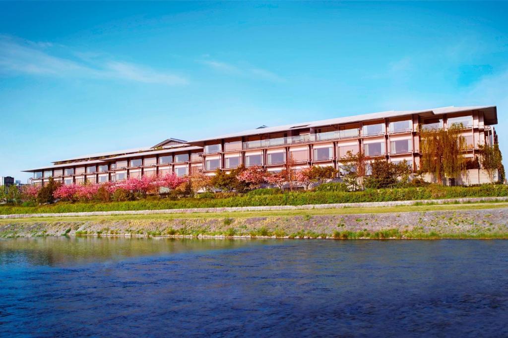 a building next to a body of water at The Ritz-Carlton Kyoto in Kyoto