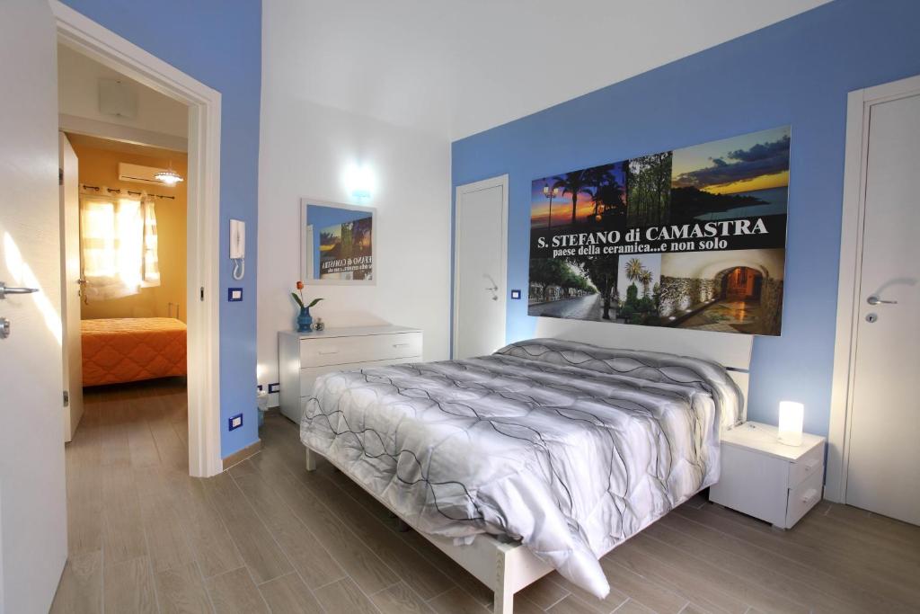 a bedroom with a large bed with a poster on the wall at B&B La Grande Mela in Santo Stefano di Camastra