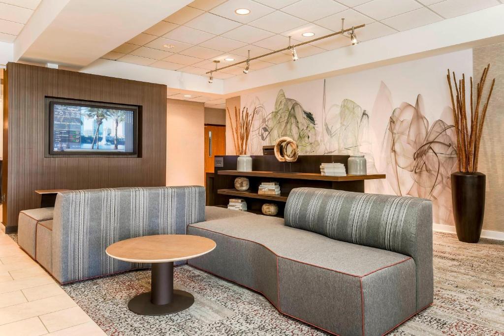a waiting room with a couch and a table at Courtyard by Marriott Orlando Lake Mary North in Lake Mary