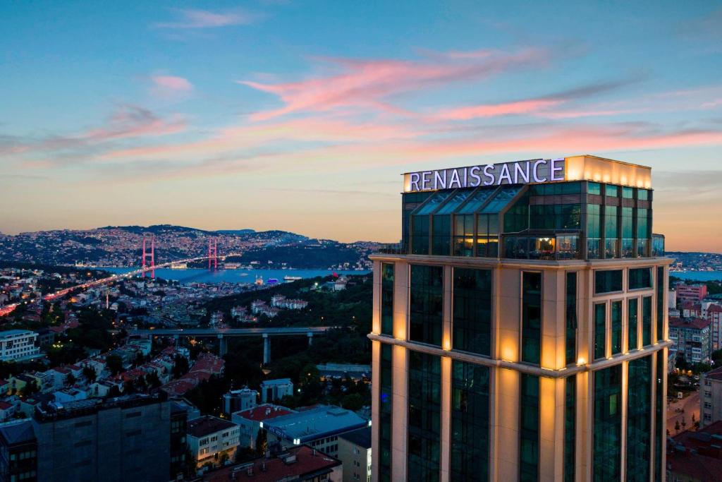 wysoki budynek z znakiem na górze w obiekcie Renaissance Istanbul Polat Bosphorus Hotel w Stambule