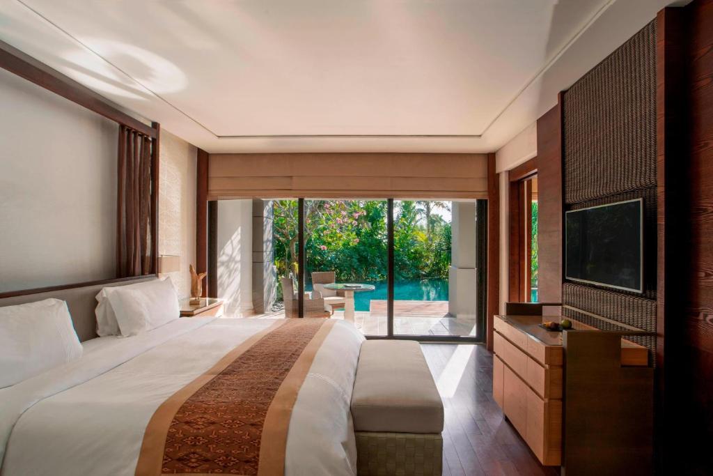a bedroom with a large bed and a television at The Ritz-Carlton Bali in Nusa Dua
