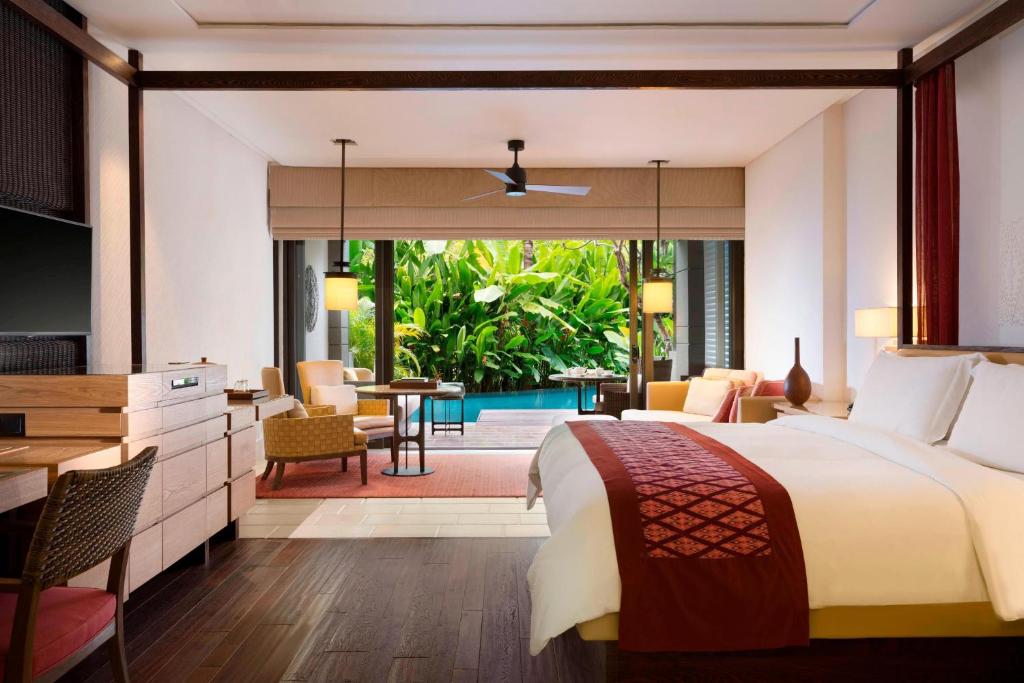 a bedroom with a large bed and a pool at The Ritz-Carlton Bali in Nusa Dua
