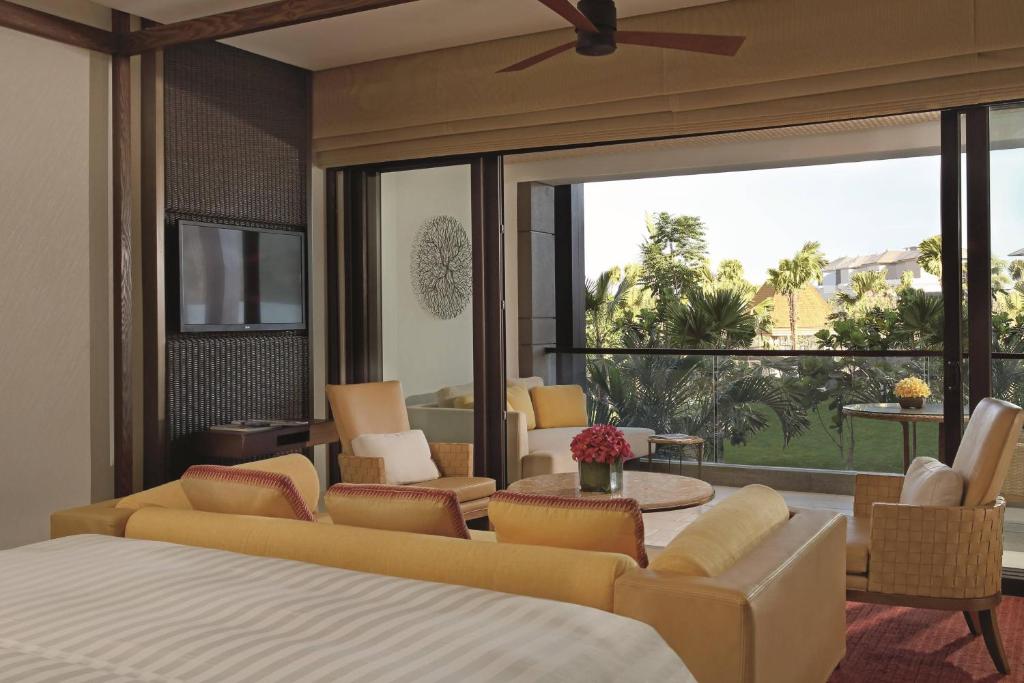 a bedroom with a bed and a living room at The Ritz-Carlton Bali in Nusa Dua