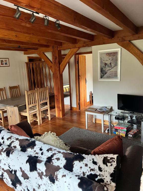 Chez Jallot - Upper Gite في Vidaillat: غرفة معيشة مع أريكة وطاولة