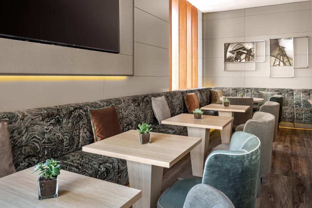 AC Hotel Ponferrada by Marriott في بونفيراذا: مطعم بطاولات وكراسي وأريكة